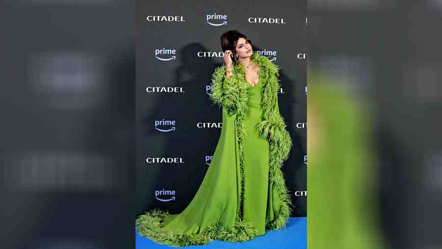 It was green for PC at the premiere of her series in Rome. The actor turned heads in a brilliant green ensemble from Valentino, featuring a voluminous cape and an extravagant feather robe. She accessorised it with Bulgari emerald green jewellery, getting the tone-on-tone memo right. Her hair was styled in a chic and messy updo, completing the stunning look.