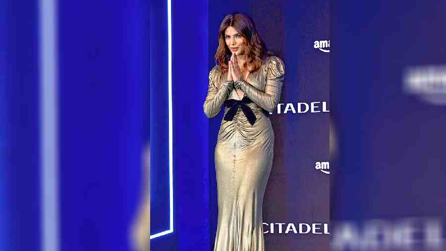 She looked sharp at the media conference in Mumbai in a lame gown that highlighted her curves. The dress featured long sleeves, structured shoulders and ruched detailing at the centre. The plunging V-neckline added a hint of sexiness to the ensemble.
