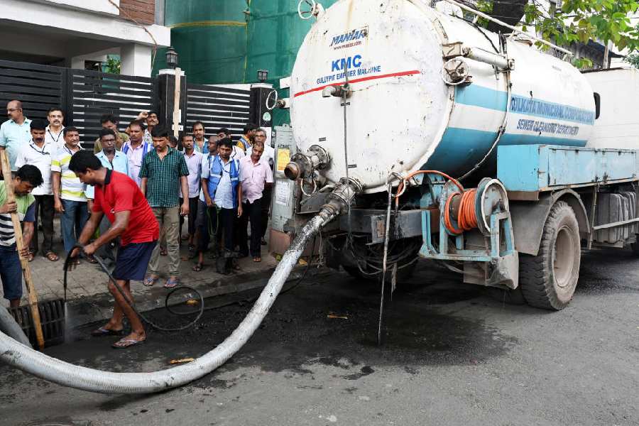 A CMC team cleans a gully pit on Justice Dwarakanath Road in Bhowanipore on Monday.