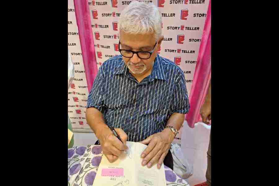 Amitav Ghosh signs a book at Storyteller Bookstore, Ballygunge