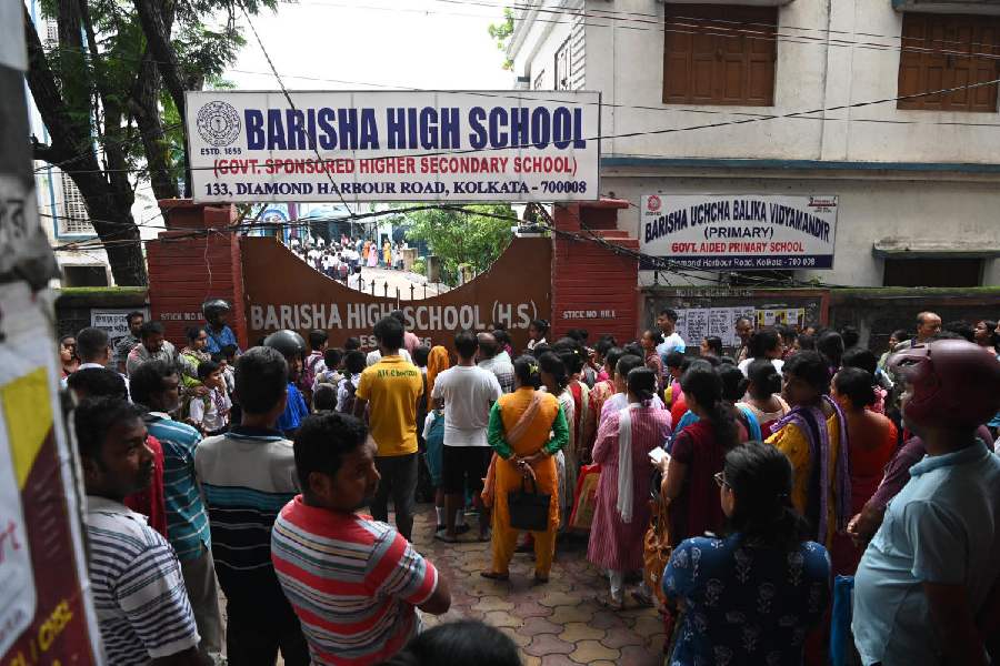 Guardians in front of Barisha Uchcha Balika Vidyamandir, the school where Souraneel Sarkar studied, near Behala Chowrasta on Monday morning.