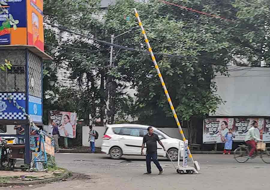 A personnel tows away a dropgate at Rabi Thakurer More (Ruby crossing) on the EM Bypass on Tuesday. Following the Behala accident last Friday, traffic police personnel have set up boom barriers and drop gates at critical crossroads and in the vicinity of schools in Kolkata 