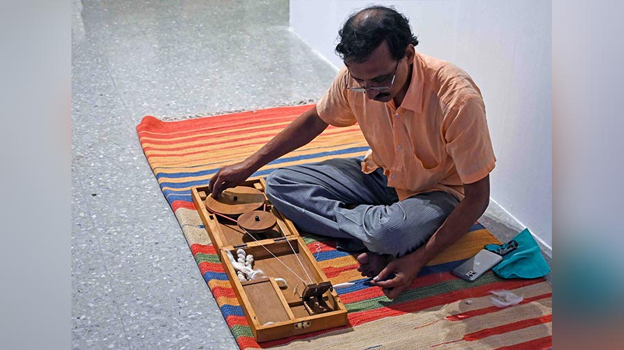 An artisan giving a live demo of the spinning of threads for weaving