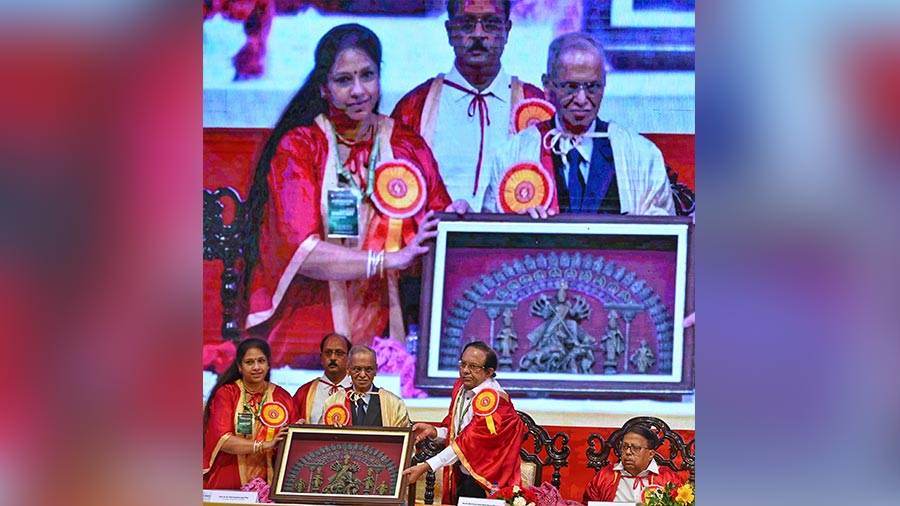 Narayana Murthy being presented with a dokra Durga idol