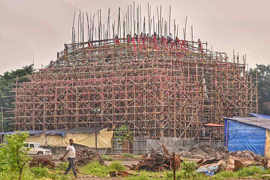 Labourers work on a pandal in Kolkata with a little over two months left for Durga Puja