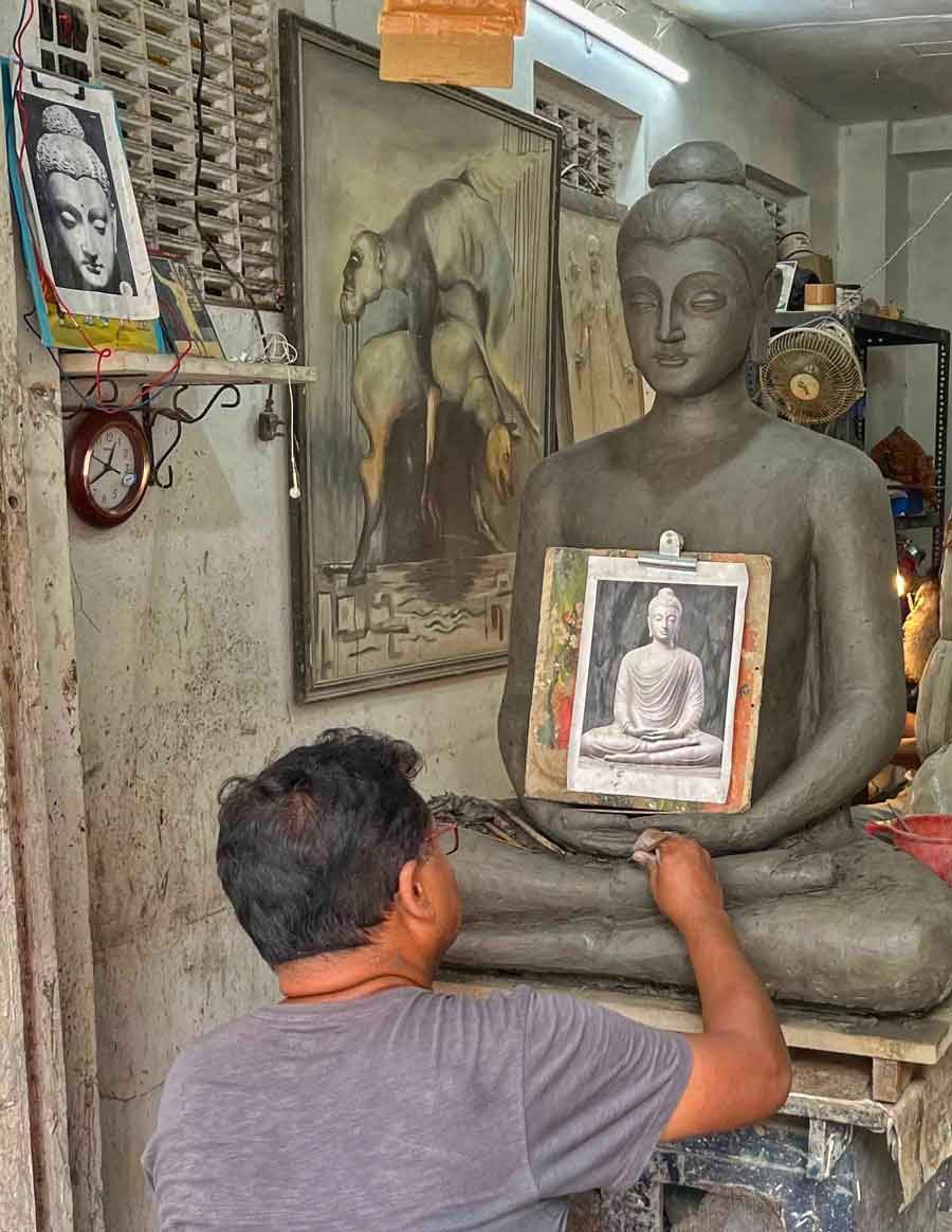 Artist Anup Paul completes a statue of Buddha at Kumartuli