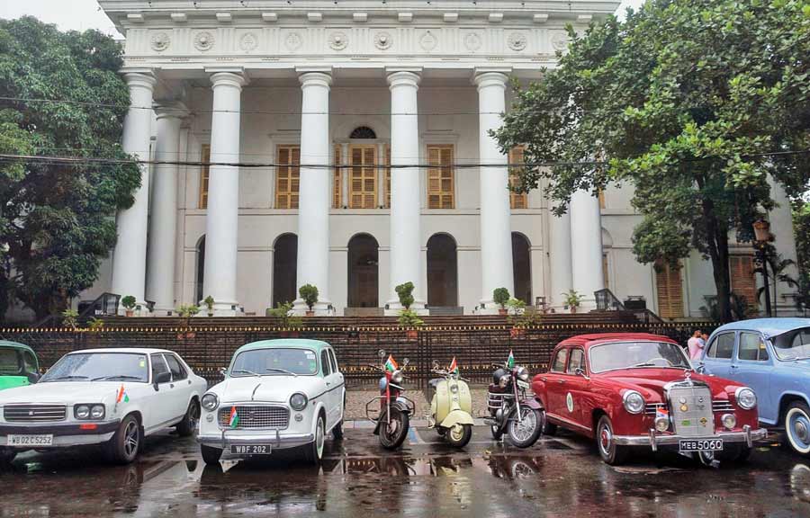 The owners of 15 vintage and classic cars and five two-wheelers embarked on their annual pre-Independence ride on a rainy Sunday morning. Starting from Town Hall, the fleet of cars reached Park Street via the AJC Bose Road flyover. My Kolkata joined the ride. One by one all 15 cars gathered in front of the Town Hall on Sunday morning. The owners pointed out that their usual gathering spot went perfectly well with their vintage vehicles. “This is one of the oldest parts of the city and the colonial-era structures provide the perfect backdrop for the starting point,” said Amritendu Roy, one of the participants with his 1964-make white Ford Anglia 105E bought in 2021. The early Sunday morning traffic slowed down and morning walkers took a few photos of this majestic sight