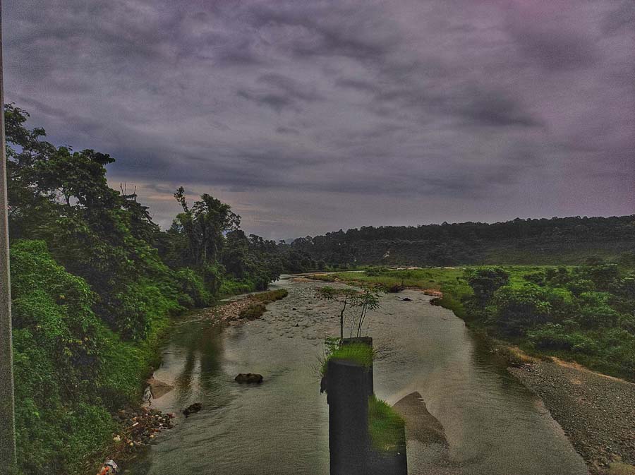 As the train trundles along a small non-descript bridge, your eyes catch the waters of the snaking Gurjan Jhora river  