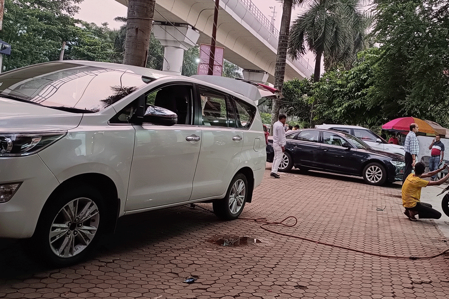 Cars parked on the footpath outside a car accessory store in DB Block.