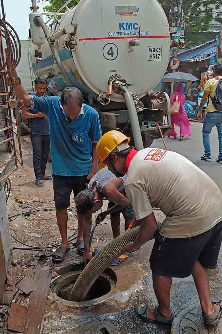 Kolkata Municipal Corporation personnel operate a gully-pit emptier to clear the sewerage system for smooth flow of rain and waste water in south Kolkata
