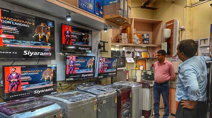 People watch the live telecast of the Chandrayaan 3 landing at an electronic appliances  shop in north Kolkata