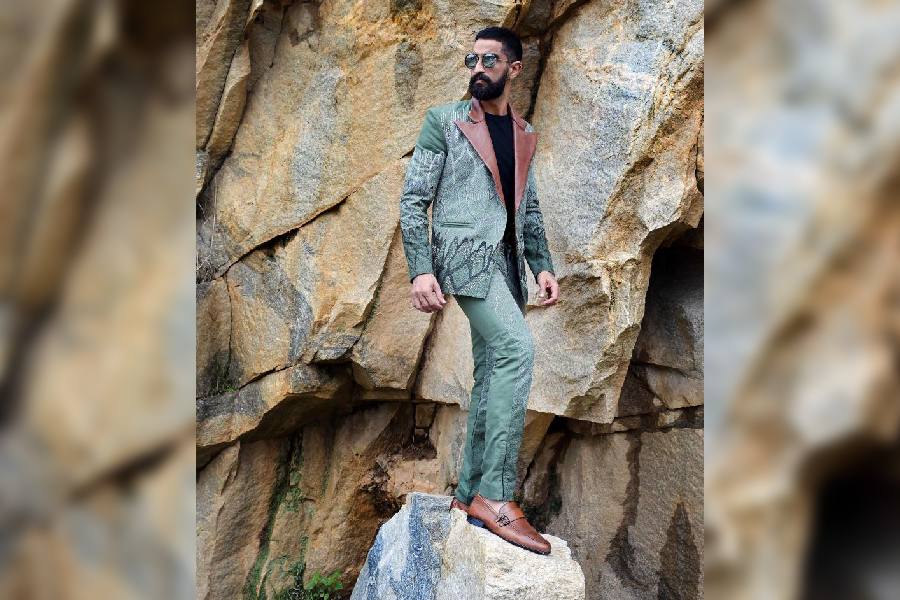 Neeraj sports an uber-smart look in the handembroidered jacket, designed with a leather lapel and teamed with matching textured pants. On-point styling with tan brown shoes and shades complete the look.