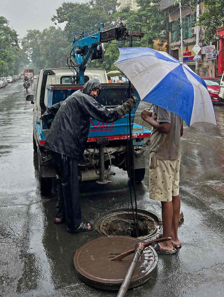 Despite heavy rain, workers of the Solid Waste Management department of Kolkata Municipal Corporation (KMC) desilted a manhole at Lenin Sarani to fight waterlogging   