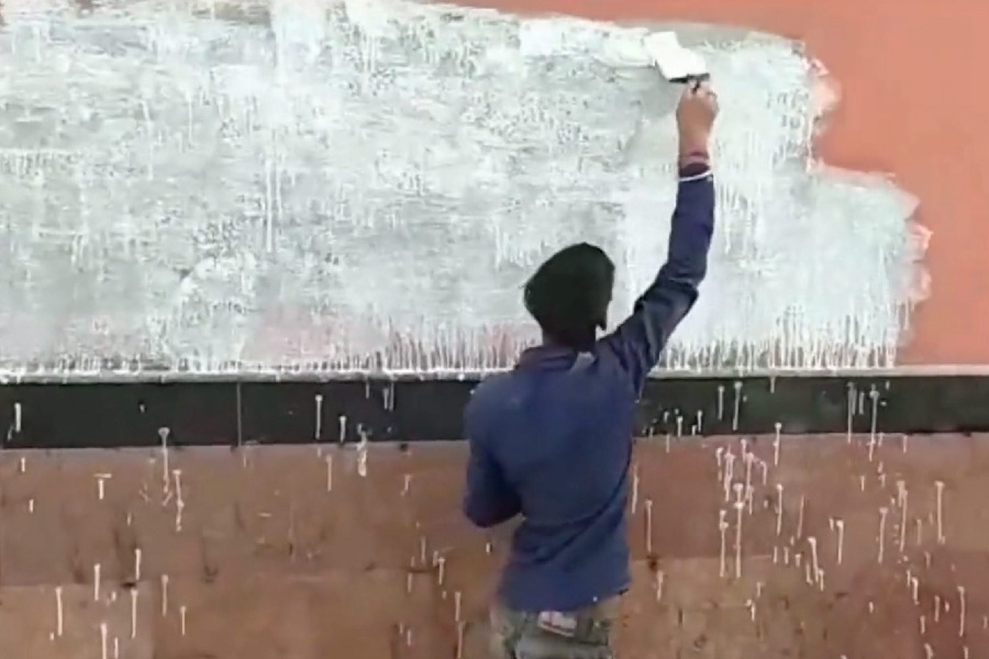 A worker paints a wall on which pro-Khalistan slogans were written at Shivaji Park metro station