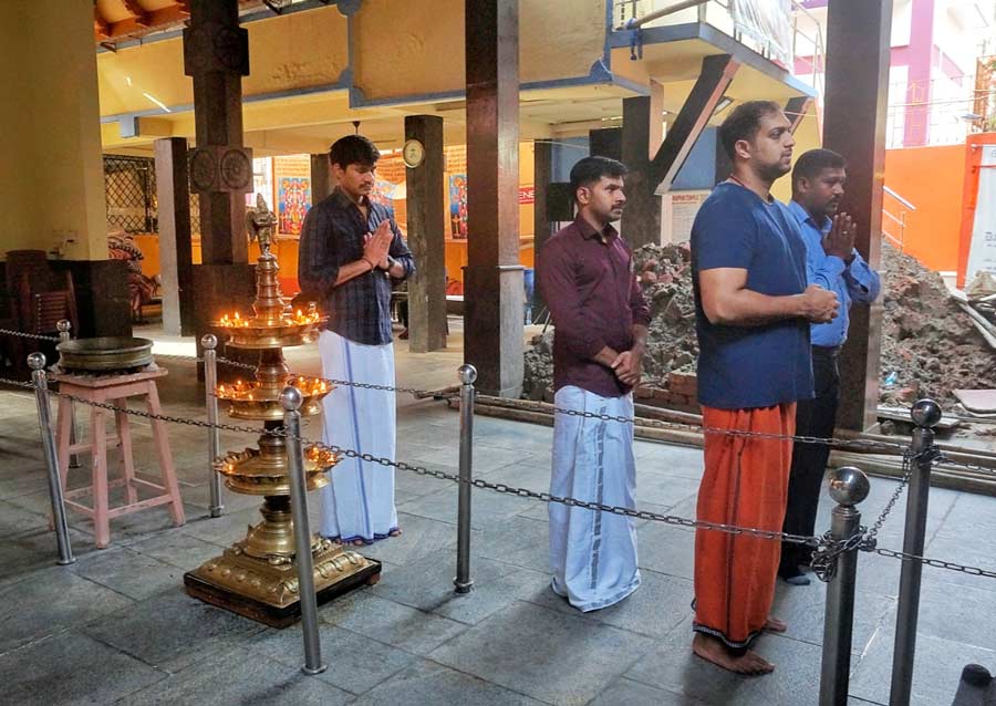  Men dressed in traditional attire pray during the aarti 