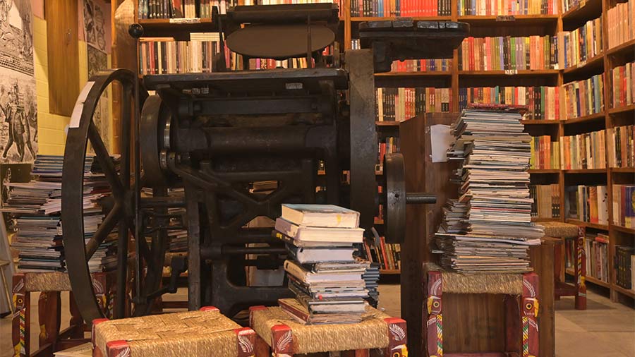 A vintage hand-operated printing machine on display at the cafe