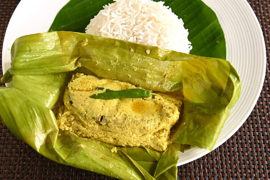 Marinated with mustard paste and mustard oil, the tender Hilsa fillet is gently wrapped in a banana leaf. This delicate dish is called Bhapa Ilish.