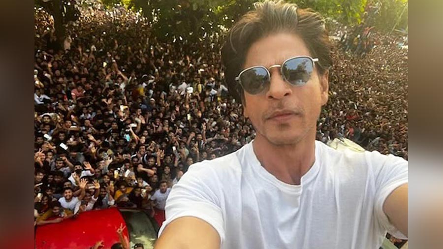 Shah Rukh Khan posing for a selfie with fans outside Mannat, his residence in Mumbai