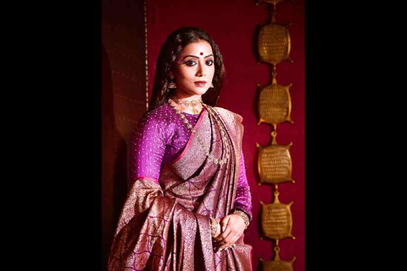 Abhijit decked up Anindita in a contemporary bridal look in this purple handcrafted katan and silk brocade Benarasi. He chose minimal make-up with black smokey eyes and a touch of pink on the lips, kept the hair open and added a small bindi to complete the look. The chandan art, combining kalka and dots around the bindi and at the end of the eyebrows on either side, added an edgy and elegant touch, complementing the overall contemporary vibe of the look