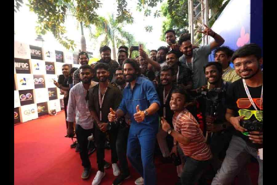 Naga Chaitanya Akkineni posing with fans on the IFFI red carpet before the screening of Dhootha