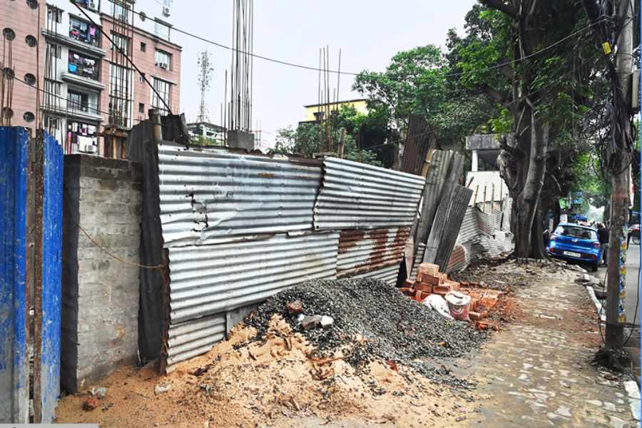 A construction site with materials dumped on the pavement along Maniktala Main Road on Friday.