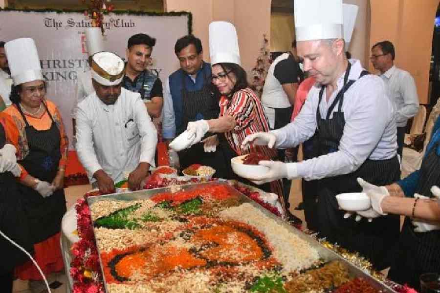 Members and guests of the club participate in the cake-mixing ceremony 