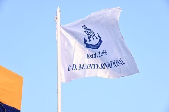 The flag of B.D.M.International soaring high.