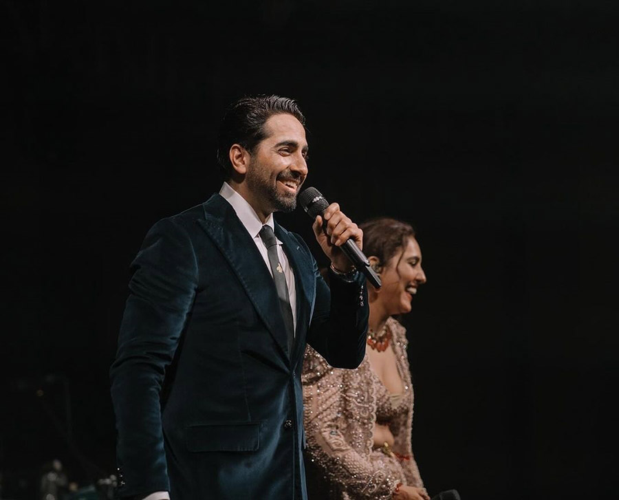 Actor Ayushmann Khurrana looked dapper in a black suit. He was snapped holding a microphone.