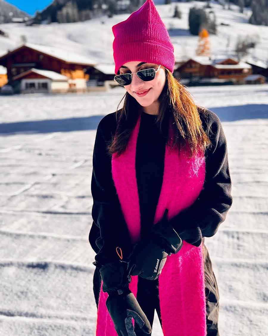 Some more pink against the white icy canvas. A long scarf and beanie in pink break the monotony of black in Rukmini’s look. Add to that a swipe of pink on the lips. 