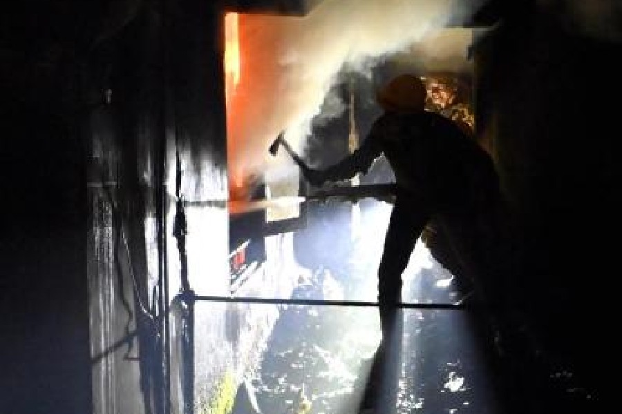 A fireman sprays water inside the third-floor apartment to douse the flames on Sunday