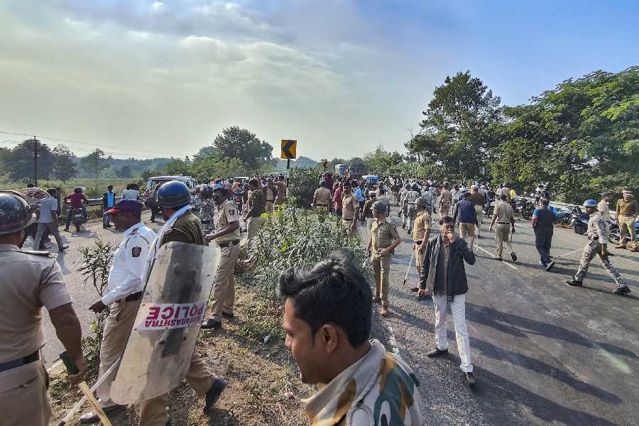 Police personnel disperse people gathered outside a manufacturing unit of Solar Industries after a blast at the factory, at Bazargaon on December 17