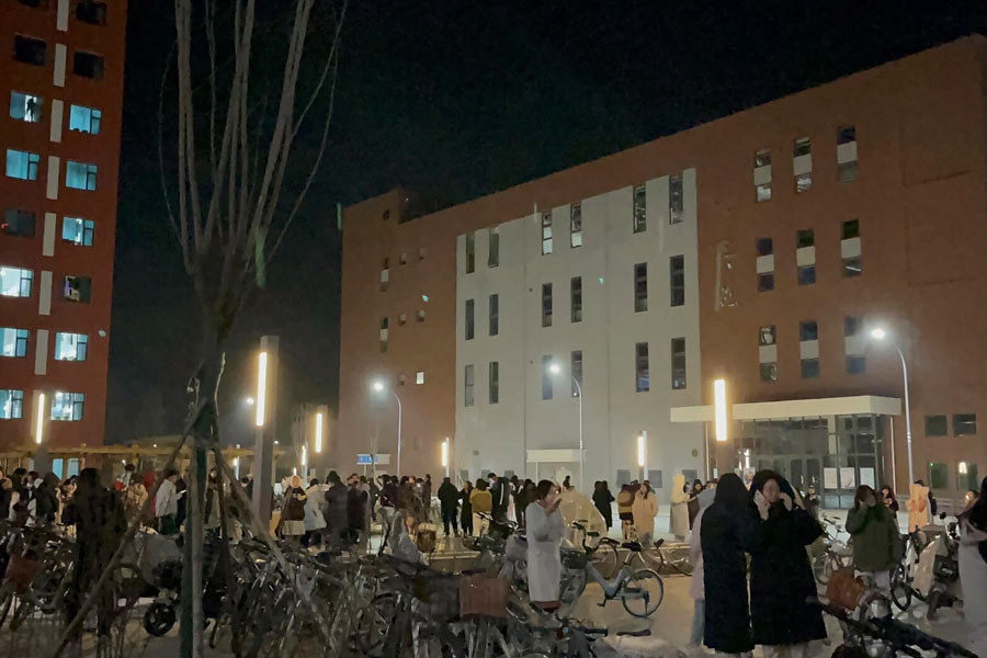 In this photo provided by Wang Xi, students gather outdoor after evacuating from their dormitories at the Lanzhou University Yuzhong campus in Lanzhou in northwestern China's Gansu province Tuesday after an earthquake hit the area.