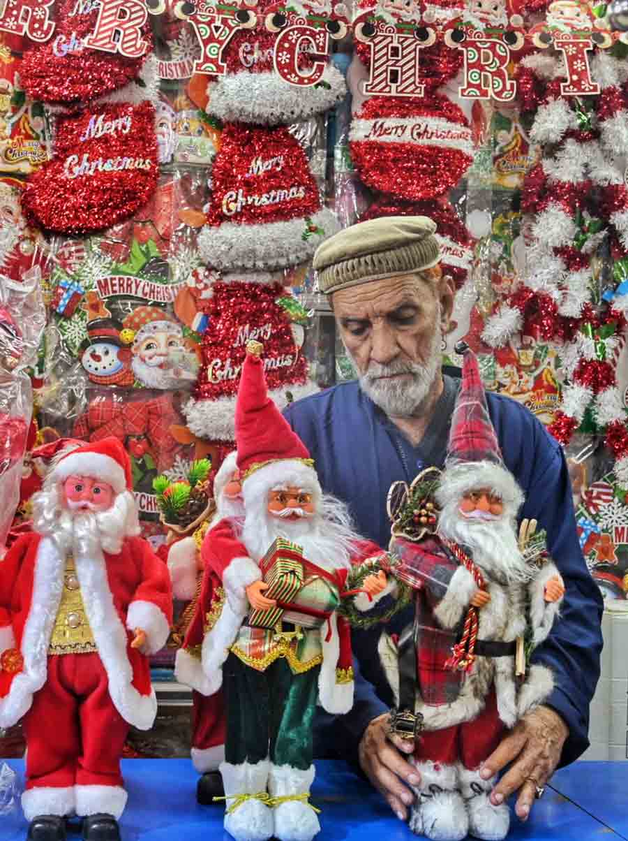 Shopkeepers decorating their shops with Santa Claus statuettes at New Market on Sunday ahead of Christmas