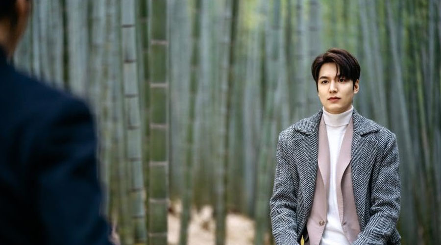 In The King (2020), streaming on Netflix, Lee Min-ho makes for a striking business tycoon in a white turtleneck tee, a dusty pink sweater and a long tweed coat. 