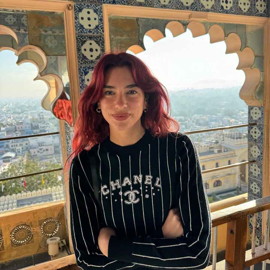 With her red wavy hair and nude makeup finish, the Physical singer went for a more casual look in a black full-sleeved Chanel tee with white stripes.
