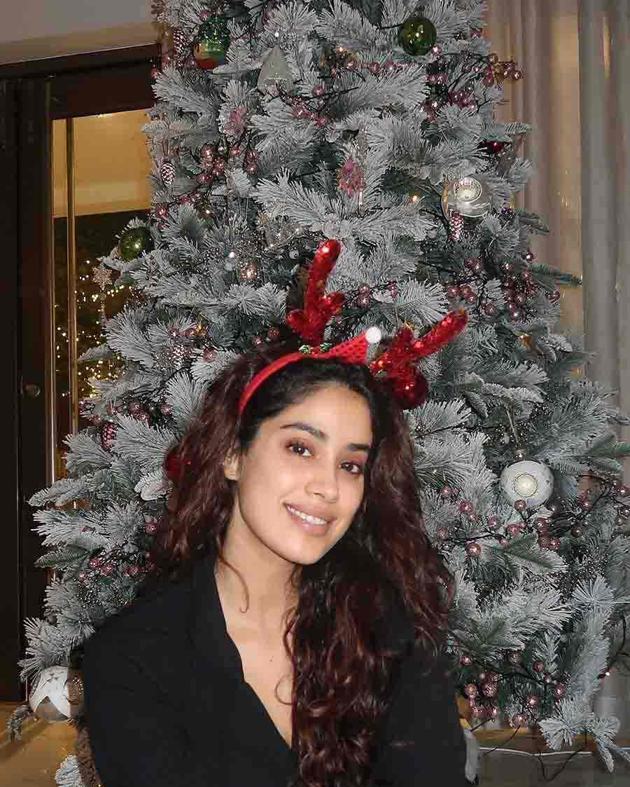 Janhvi Kapoor sported a casual look. Dressed in a solid black V-neck t-shirt paired with red sequined reindeer horns, the 26-year-old actress posed alongside a Christmas tree. 