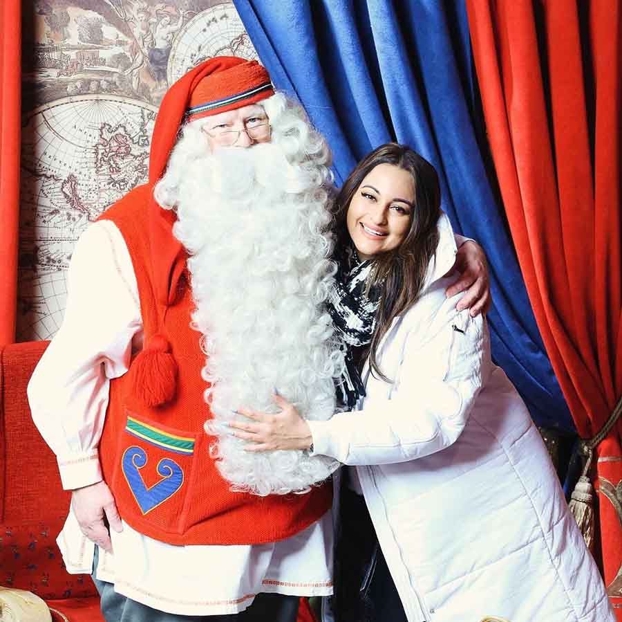 Sonakshi Sinha sported a white parka jacket and posed for a picture with a man dressed as Santa Clause.  