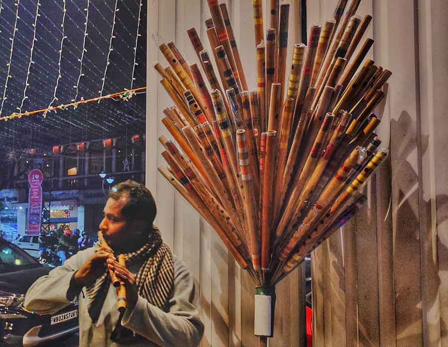 A flute-seller showcases his skills while he tries to attract buyers at Park Street on Tuesday