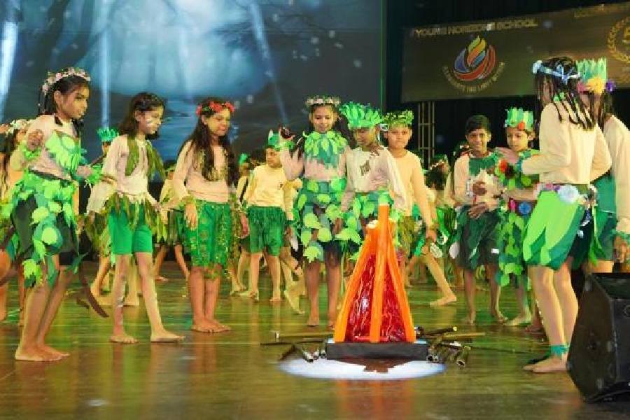 Students of Young Horizon School play the primal humans during a performance to celebrate their 50 years