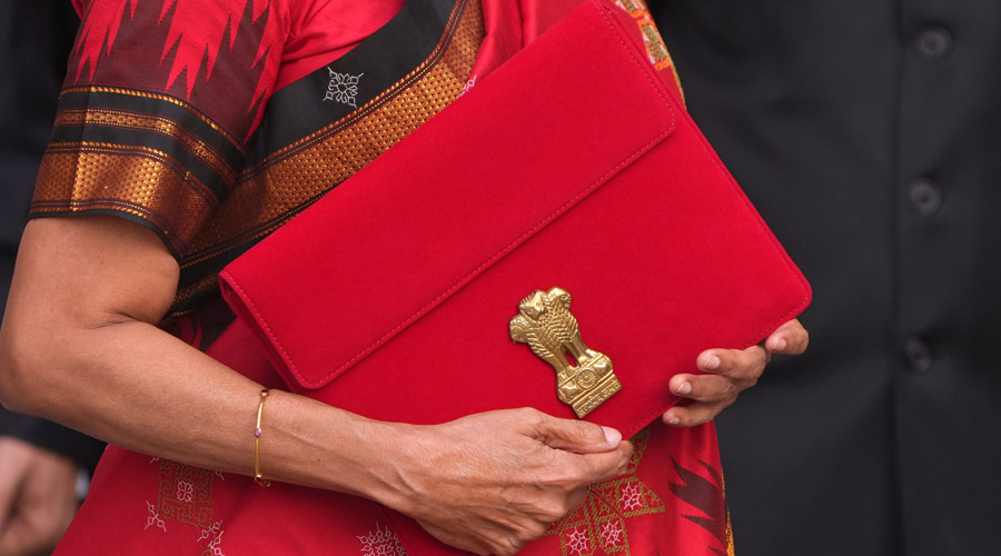 Union Finance Minister Nirmala carrying a folder-case poses for photographs outside the Finance Ministry at North Block in New Delhi.