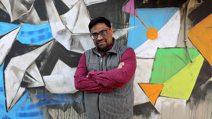 Debraj Goswami posing in front of his wall art