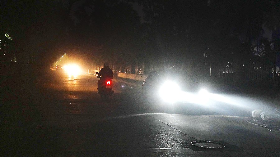 Vehicles move with their headlights on through a dark Canalside Road in Salt Lake