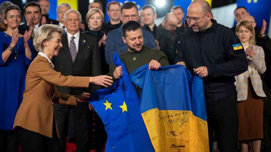 European Commission President Ursula von der Leyen, Ukrainian President Volodymyr Zelenskyy and Prime Minister Denys Shmyhal hold the flags of the EU and Ukraine