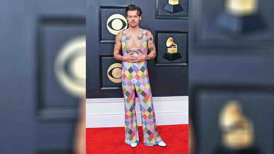 Watermelon Sugar singer Harry Styles loves fluid fashion and we know it. He turned up in a patchy rainbow EgonLab jumpsuit with a plunging neckline, putting his tattoos and biceps on display. Sleek layered chain adorned his neck. Honestly we are not a fan of the outfit but Harry in it? We love!