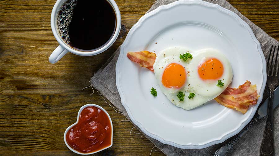 Heart-shaped salami with poached eggs and bacon