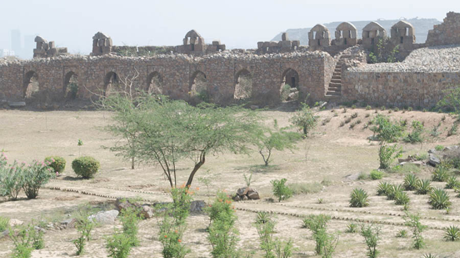 Interiors of the Adilabad Fort. Manicured lawns in the foreground and boundary walls with battlements on the background 