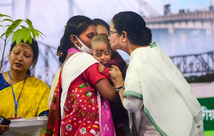 West Bengal chief minister Mamata Banerjee interacts with a child at an event in Howrah on Thursday.  Benefits in connection with various schemes of the state government were handed over to the beneficiaries in the event