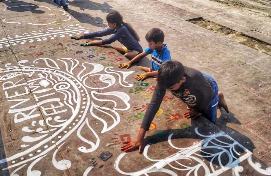 Kids hand-paint on an ‘alpona’ at Ahiritola Ghat River Festival on Saturday. A photography exhibition was also organised at the event
