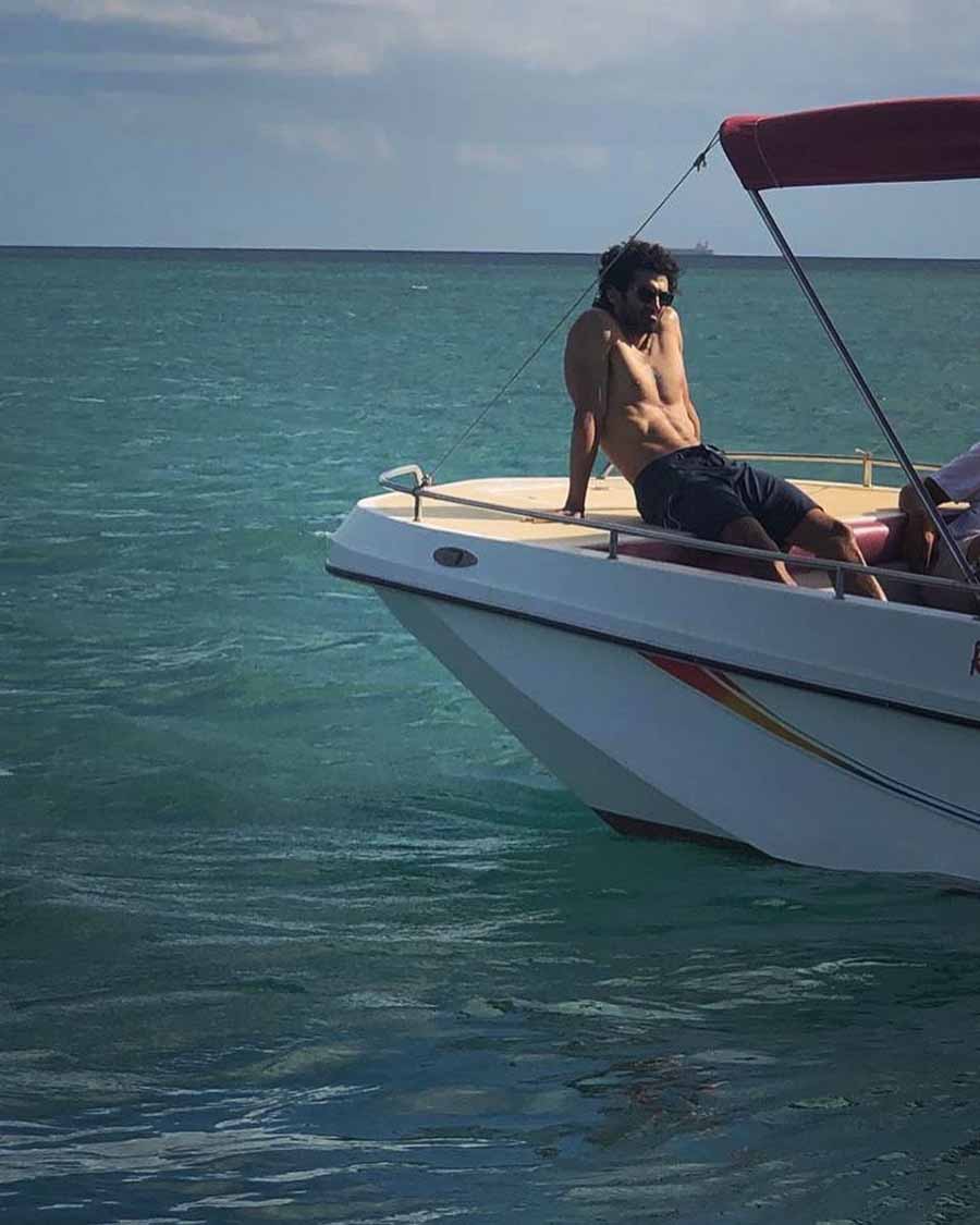 Aditya flaunts his ripped body as he poses shirtless on a boat.