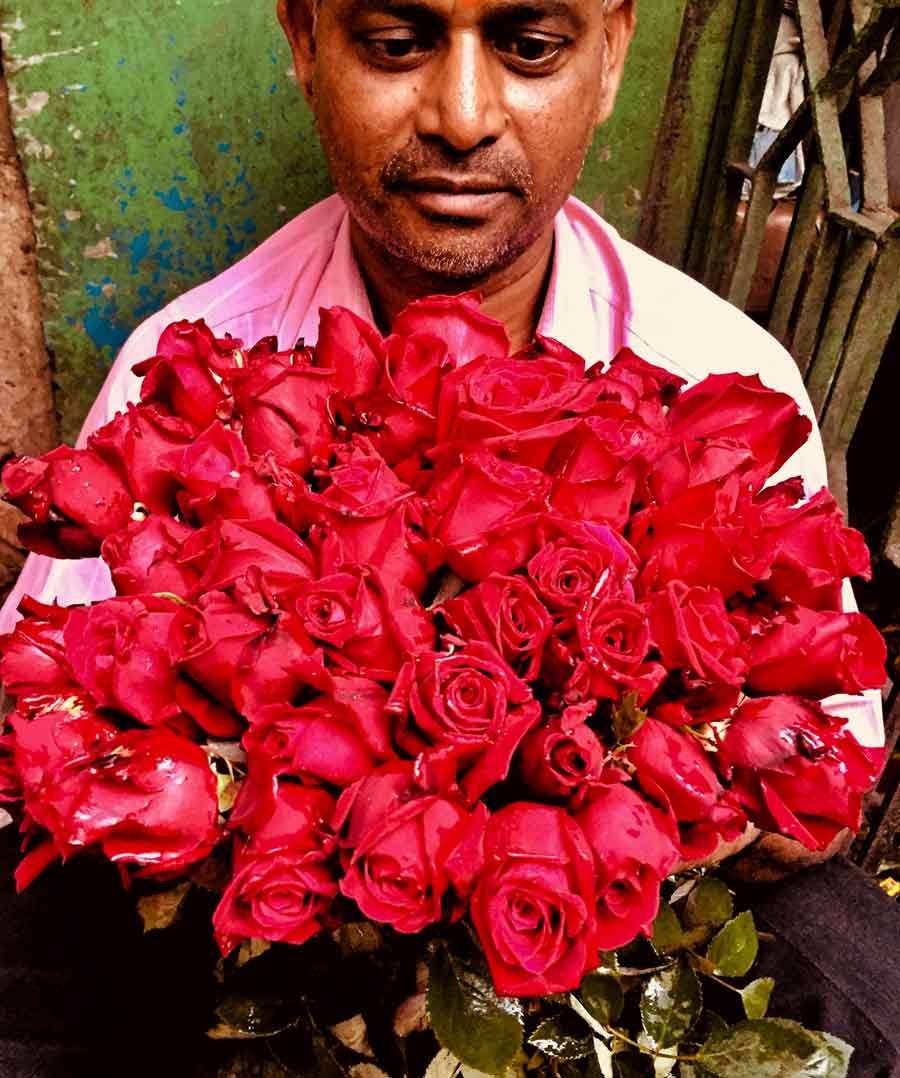 A flower-seller displays a rose bouquet at the Howrah flower market a day before Valentine’s Day